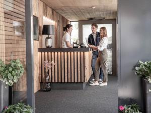 een groep mensen die aan een bar in een kamer staan bij Belmonte Tirol - Boutique Hotel in Sillian