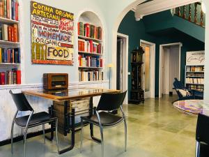 una biblioteca con una mesa con sillas y libros en Carmen Guillemot, en Alcanar