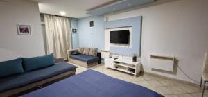 sala de estar con sofá azul y TV en Apartman Nives, en Prijedor