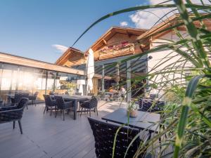 un patio con mesas y sillas en un edificio en Belmonte Tirol - Boutique Hotel, en Sillian