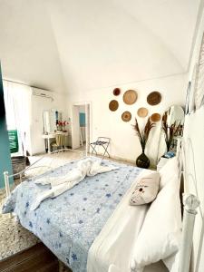 a bedroom with a white bed with a blue blanket at DIMORA ELIVA in Monopoli