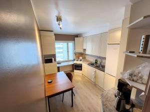 a small kitchen with a wooden table and a refrigerator at Inspiring Apartment near city center in Mikkeli