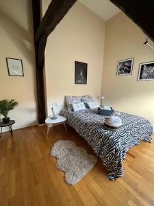une chambre avec un lit à imprimé zèbre et un tapis dans l'établissement Les Gites d'Albatre, le 44, à Dieppe