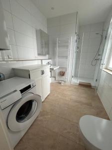 a white bathroom with a washing machine in it at Exklusives Haus, ruhig, zentral, lichtdurchflutet, im Innenhof in Karlsruhe