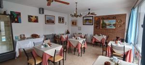 um restaurante com mesas e cadeiras num quarto em Posada El Betel em Villa Carlos Paz