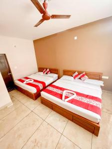 dos camas sentadas una al lado de la otra en una habitación en Luxe Hotel - Rooms & Villas Wayanad en Wayanad