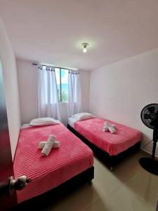 two beds in a room with red sheets at Apartment Medellinsabaneta near metro station in Sabaneta