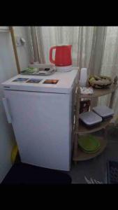 einen weißen Kühlschrank mit einem roten Topf drauf. in der Unterkunft KARETS VIEW les pieds dans l eau - feet in water in Marigot