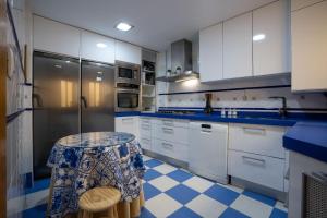 uma cozinha com armários brancos e um piso azul e branco em Reina Aixa- Apartamento Centro em Granada