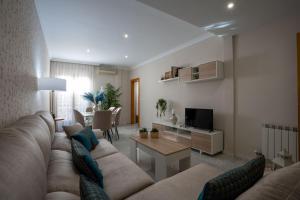 uma sala de estar com um sofá e uma mesa em Reina Aixa- Apartamento Centro em Granada