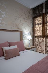 Un dormitorio con una gran cama blanca y una lámpara en Reina Aixa- Apartamento Centro en Granada