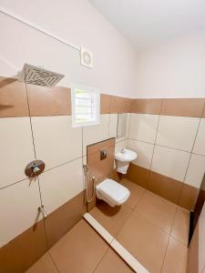 a bathroom with a toilet and a sink at Luxe Hotel - Rooms & Villas Wayanad in Wayanad