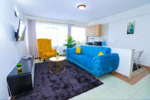 un salon avec un canapé bleu et un fauteuil jaune dans l'établissement Betty's staycation Thika road, à Nairobi