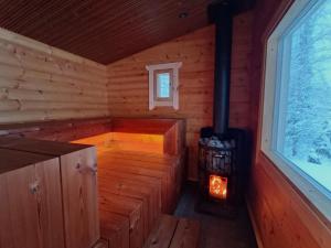 an inside view of a log cabin with a wood stove at Mökki ulkoporealtaalla in Uurainen