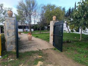 a gate with a vase in the middle of a driveway at Las Casitas de Higuera in Higuera de la Sierra