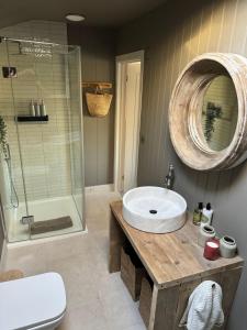 a bathroom with a sink and a shower and a mirror at Appleby Barn in Lacock