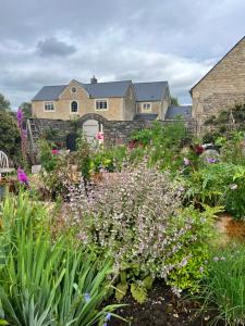 a garden with flowers in front of a house at Appleby Barn in Lacock