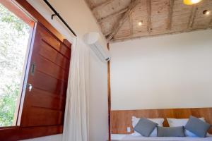 a bedroom with a bed with a window and a curtain at Pousada Rancho Soberbo, Serra do Cipó in Santana do Riacho