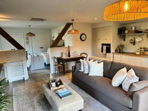 a living room with a couch and a kitchen at Appleby Barn in Lacock