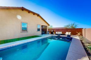 a swimming pool with two chairs and a house at Phoenix Star - Main House & Casita in Phoenix