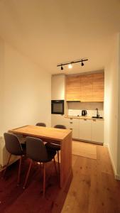 cocina con mesa de madera y sillas en Apartman Dani, en Bjelašnica