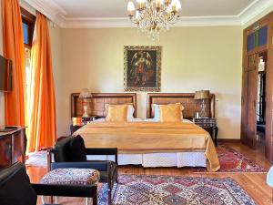 ein Schlafzimmer mit einem großen Bett und einem Kronleuchter in der Unterkunft Villa Maria Pousada de Charme in Brotas