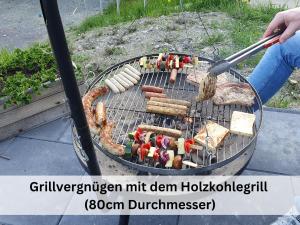 a person is cooking food on a grill at Großes Ferienhaus für 16 Pers mit Indoorspielplatz, Pool, großer Terrasse, Grill, Sauna, Kicker, Dart, uvm - ideal für Familien in Schmallenberg