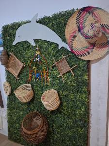 a painting of a dolphin and straw hats on grass at Pousada Angatu alter in Alter do Chao