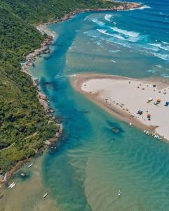 an aerial view of a beach with people in the water at Apartamento praia de fora in Palhoça