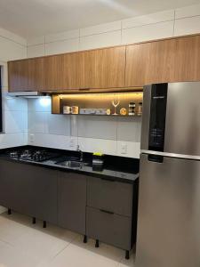 a kitchen with a stove and a refrigerator in it at Apartamento praia de fora in Palhoça