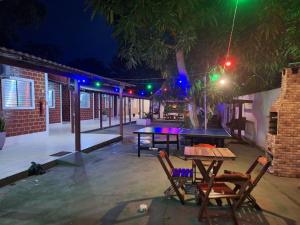 a patio with a table and chairs at night at Pousada Angatu alter in Alter do Chao