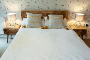 een wit bed met 2 nachtkastjes en 2 lampen bij Gorgeous 2BR Apartment with City Views in Leeds