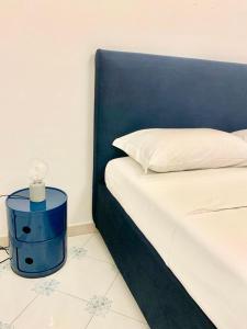 サレルノにあるDimora dei Mercantiのベッド1台(青いヘッドボード、白い枕付)