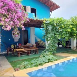 uma villa com piscina e uma casa com flores em Casa Tudo Azul em Amontada