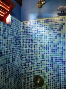 La salle de bains est revêtue de carrelage bleu et revêtue de carrelage bleu. dans l'établissement Casa Encantada Guest House, à La Aguada