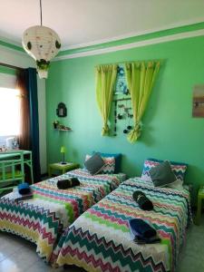 two beds sitting next to each other in a bedroom at MAISON D HÔTES Marine KSAR SGHIR in Ksar es Sghir