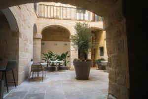 cortile con tavolo e pianta in vaso di IBB Hotel Palazzo Bettina Malta a Birgu (Vittoriosa)