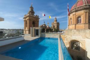 a swimming pool on the roof of a building at IBB Hotel Palazzo Bettina Malta in Birgu