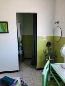 a room with a green and white wall and a table at MAISON D HÔTES Marine KSAR SGHIR in Ksar es Sghir