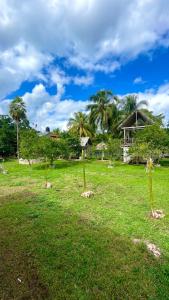 drei Pole auf einem Feld mit einem Haus im Hintergrund in der Unterkunft Rancho Los Quiñones in Leona Vicario