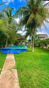 einen Pool mit Palmen auf einem Feld in der Unterkunft Rancho Los Quiñones in Leona Vicario