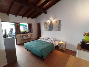 Un dormitorio con una cama y una mesa. en Finca La Sirena Vacation Apartments, en Garachico