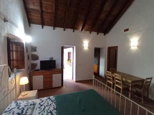a bedroom with a bed and a table and a dining room at Finca La Sirena Vacation Apartments in Garachico