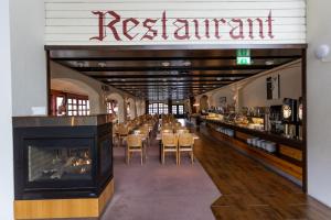 a restaurant with a fireplace and tables and chairs at Stryn Hotel in Stryn +19 photos