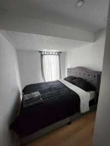 a bedroom with a black bed with a window at Foresight Chalet Laidlaw in Timmins