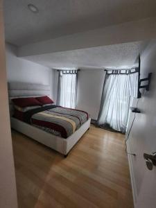 1 dormitorio con 1 cama y 2 ventanas en Foresight Chalet Laidlaw, en Timmins