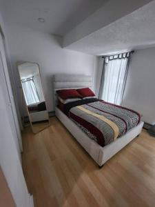 1 dormitorio con cama y espejo. en Foresight Chalet Laidlaw en Timmins