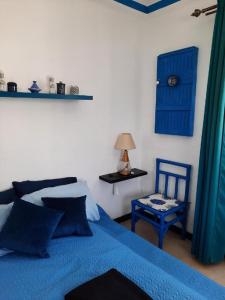 - une chambre avec un lit bleu et une chaise bleue dans l'établissement MAISON D HÔTES Marine KSAR SGHIR, à Ksar Sghir