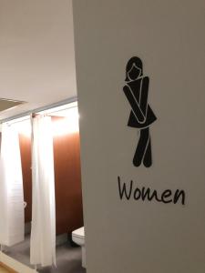 un bagno con un cartello di una donna sul muro di Urban rest zone and coworking ad Arrecife