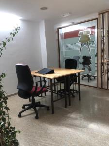 an office with a table with chairs and a laptop on it at Urban rest zone and coworking in Arrecife